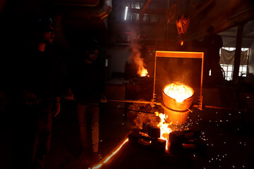 Worker controlling metal melting in furnaces.