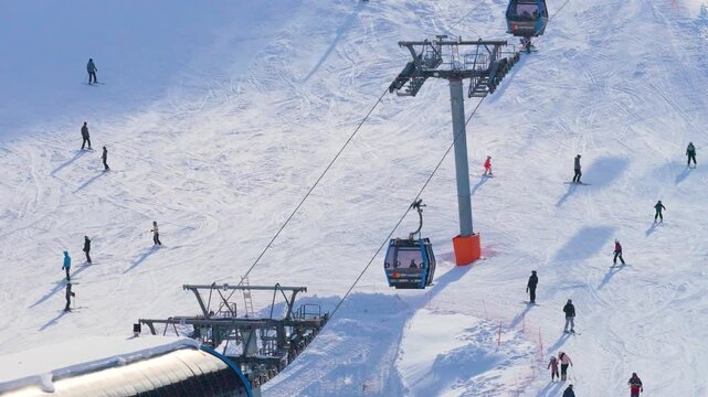 Jahorina, Bosnia and Herzegovina &ndash; January 14, 2026: Close aerial view of the Poljice gondola line with skiers moving along the adjacent ski slope