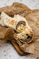 doner kebab, shawarma is a shawarma with a filling of fresh vegetables and meat. with a lot of spices. served in a restaurant. on a dark background. for menus and advertisements