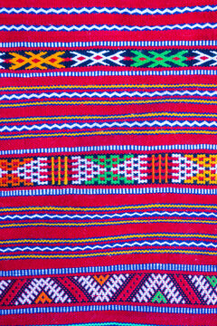 Colorful geometric pattern with vibrant red, green, and yellow stripes and shapes. Ouarzazate, Morocco