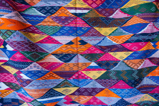 Vibrant geometric pattern with colorful triangles on a woven fabric surface. Ouarzazate, Morocco