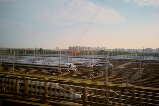 Rows of sleek high-speed trains parked in a vast railway yard under a clear sky. Chengdu, Sichuan, China