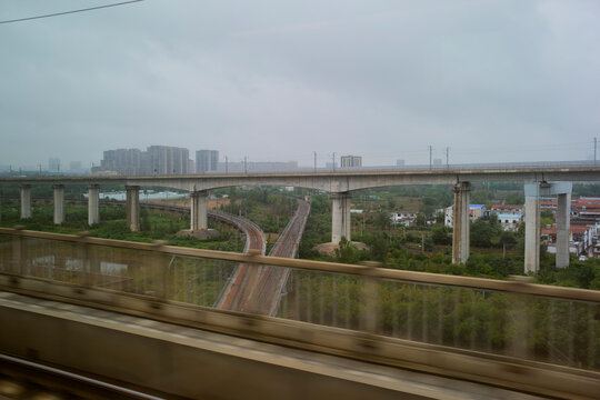 Urban high-speed train tracks with elevated railway and city skyline in the distance. Chengdu, Sichuan, China