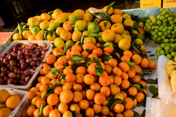 A vibrant assortment of citrus fruits and grapes displayed at a market stall. Chengdu, Sichuan, China
