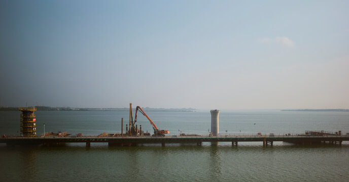 A serene construction site by a calm sea under a clear blue sky. Chengdu, Sichuan, China