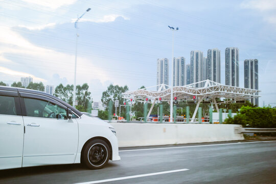 White car driving on a highway with city skyscrapers in the background Guangzhou, Guangdong, China