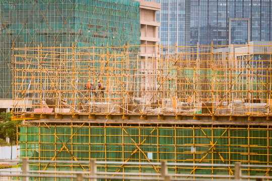Construction site with scaffolding and workers building a multi-story structure in an urban area Trip from Guilin to Chengdu, Guangxi, Sichuan, China