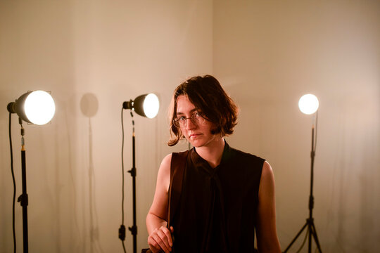 Person with shoulder-length hair standing in front of studio lights in a minimalist room. Hongkong, China