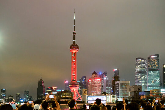 Skyline of Shanghai with illuminated Oriental Pearl Tower at night under cloudy sky. Shanghai, China