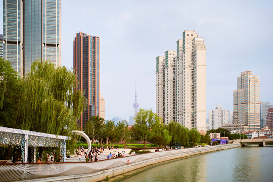 City skyline with modern skyscrapers and a riverside park under a clear sky. Shanghai, China