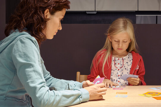 Two people playing a card game at a table; focused and engaged in their activity. Germany