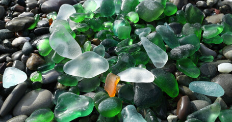 Glass sea pebbles of different colours on shore, beach. Nature and ecology. Background for design.
