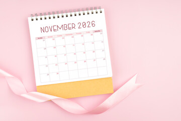 November 2026 desk calendar with pink pastel ribbon.