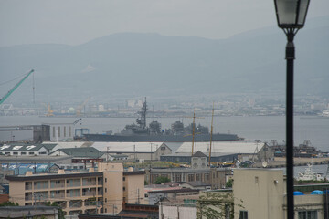 Japanese Naval Vessel Docked at Hakodate Port with Urban Backdrop
