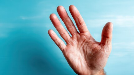 A close-up of an outstretched human hand set against a smooth blue backdrop, symbolizing connection, interaction, and the human desire for engagement or communication.