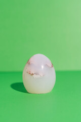 Silicone egg on green background, minimal Easter decoration. High quality photo
