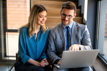 Portrait of successful business people working, talking together in corporate office during work.