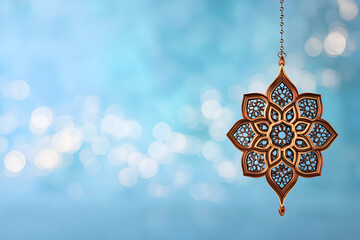 Intricate hanging decoration against a blue background with light reflections during bright daylight