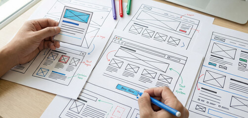 A designer working on wireframe sketches for web design layouts as part generic the computer planning process.