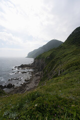  Lush Coastal Hills and Rocky Shoreline in Hakodate, Japan

