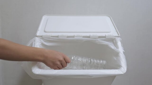 Video of a child hand opening recycling bin and placing plastic bottles inside. Kids eco education, environmental awareness, plastic recycling, sustainability, zero waste lifestyle, green future, fami