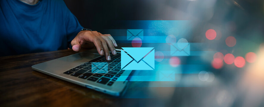 Modern Email Communication and Digital Marketing Concept, User Working on Laptop with Floating Blue Envelope Icons.