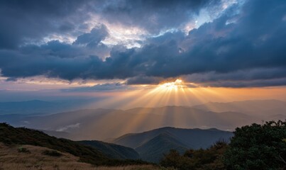 Stunning sunset with dramatic clouds and sun rays over mountain range