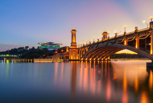 Seri Gemilang Bridge at Putrajaya, with a purple sky and water reflections.
