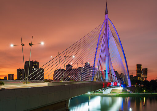 Seri Gemilang Bridge at Putrajaya during sunset with orange sky.