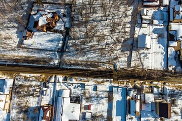 Stunning aerial winter vista of snow-blanketed houses and stark trees casting long shadows across...