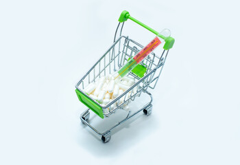Shopping basket with medicines and thermometer on white background.