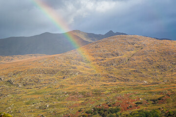 A rainbow arcs across the MacGillycuddy's Reeks mountains, seen from Moll's Gap, a mountain pass on the Ring of Kerry, in Killarney National Park, Ireland