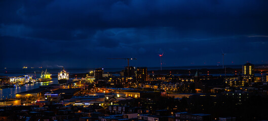 Obraz premium Ijmuiden Netherlands aerial view at night. Old dancing houses, canals, river channel and ships, canals with bridges, old european city landscape from above.