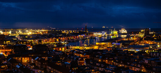 Fototapeta premium Ijmuiden Netherlands aerial view at night. Old dancing houses, canals, river channel and ships, canals with bridges, old european city landscape from above.