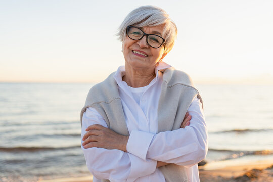 Outdoor portrait of confident stylish European middle aged senior woman. Older mature lady smiling on beach. Happy attractive senior female looking camera close up face headshot portrait. Happy people