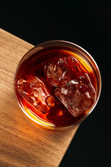 Top view of Negroni cocktail with orange peel on wooden surface