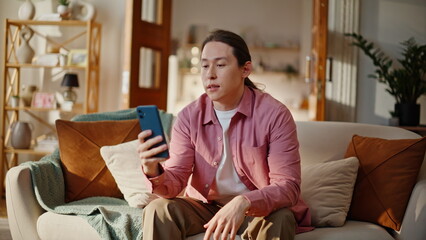 Obraz premium Asian student talking webcam chat video call smartphone sitting couch closeup