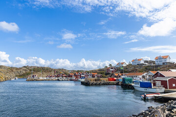 Harbor scene island Stora Dyron in Sweden, with red houses, flags, and moored boats by the dock
