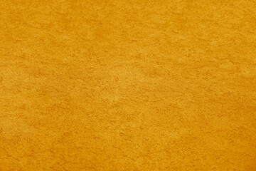 Background of natural yellow gold golden stucco in plaster cement texture lined pattern or stone in colors aged Textured illuminated wall fence surface blend of warm sunny tones backdrop.