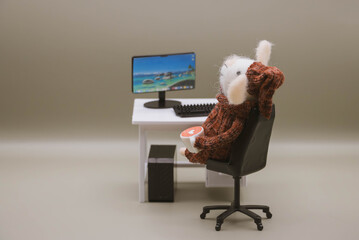 Cute felt mouse working at desk with computer and coffee, miniature office workspace concept, work from home, work remotly
