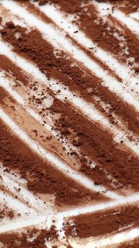 Organic dark cocoa powder rotating on white background for advertising, vertical video