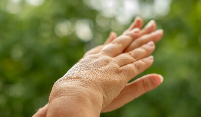 gentle application cream on hand, highlighting daily skincare rituals and self-care in nature, nourishment moisturizer gently spread across hand, gesture attention to skin health and well-being