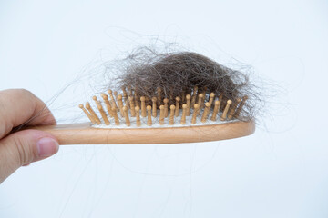woman holds clump hair after brushing, stress-related hair loss, wooden comb, brush in female hand, health, causes, symptoms and treatment alopecia, hormonal imbalance