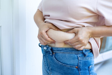 Overweight abdomen, woman's belly, excess skin, weight loss challenge, Female hands holding stomach fat, midsection, body positivity