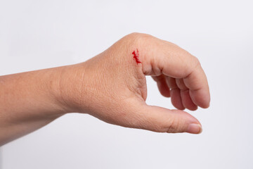drop of red blood, close-up of female hand, Woman injured at home with knife or other sharp object, concept domestic injury, negligence in cooking at home