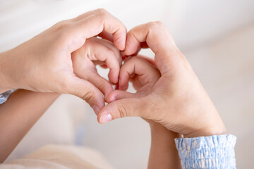 mother and daughter form heart with hands, intergenerational connection female generations, heartwarming image generations women