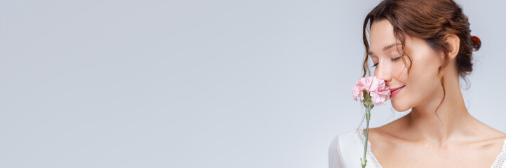 Peaceful Woman Smelling Pink Carnation in Soft Romantic Studio Portrait