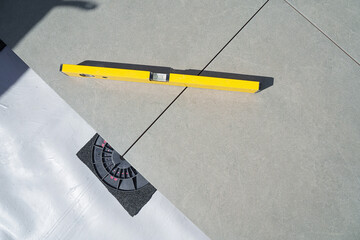 Laying tiles concept. Tiler, spatula and glue when laying tiles with close up hands. Stilts and...