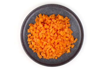 Diced carrot on black plate, isolated on white background
