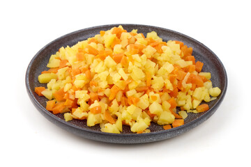 Diced potatoes and carrots fill a patterned black plate, isolated on white background.